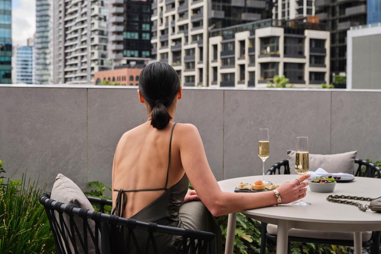 Melbourne Marriott Hotel Docklands Exteriér fotografie A woman sitting on a balcony